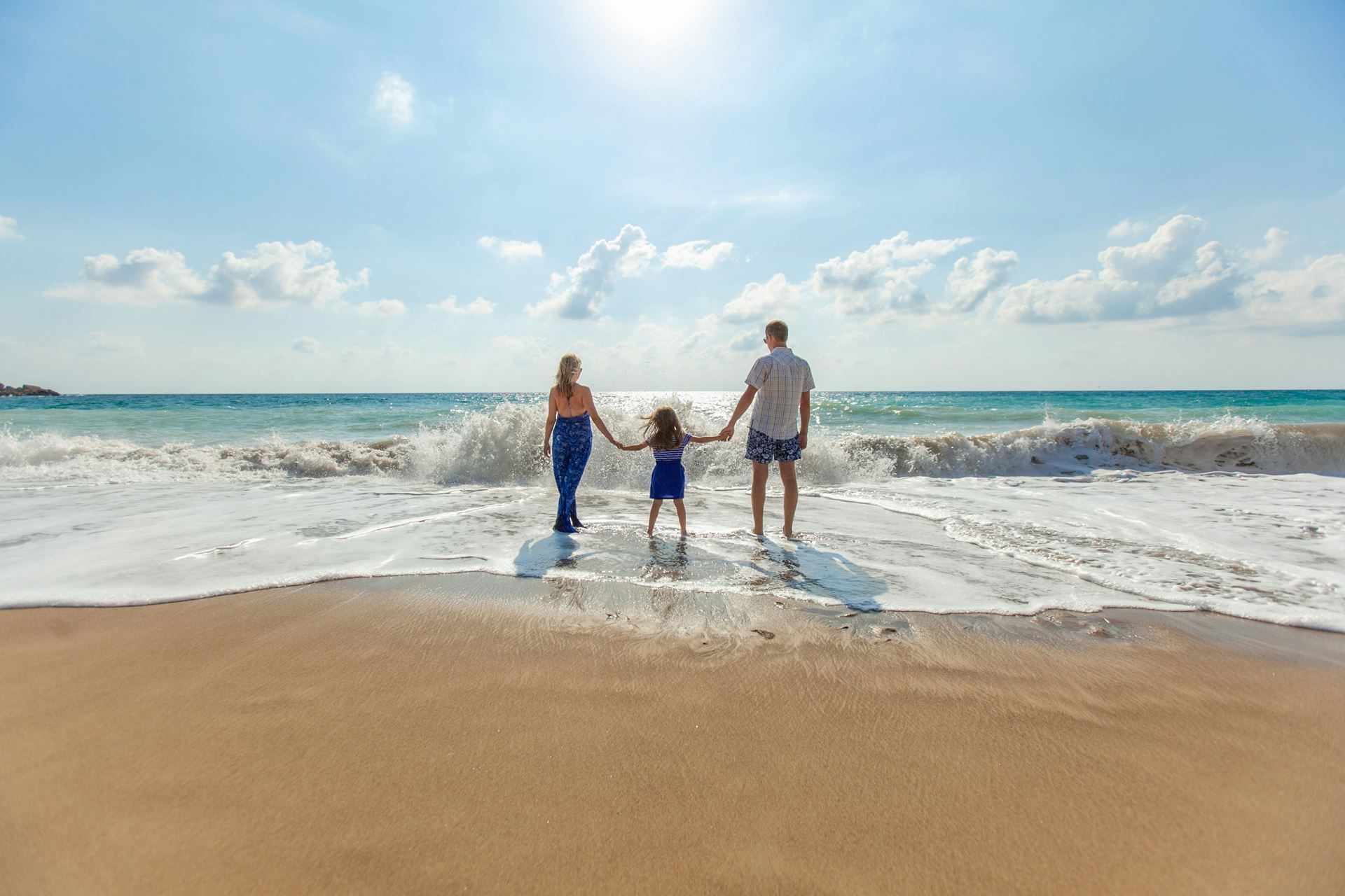 a family on the beach watching waves comes ashore